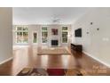 Bright living room featuring hardwood floors, fireplace, and abundant natural light at 12013 Regent Ridge Ln, Charlotte, NC 28278