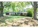 Beautiful one-story brick home with lush green lawn and mature trees providing shade at 1211 Starlight Dr, Shelby, NC 28152