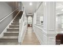 Inviting hallway with hardwood floors and staircase leading to the upper level, seamlessly connecting the home's spaces at 13032 Windy Lea Ln, Huntersville, NC 28078