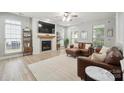 Cozy living room with a fireplace, lots of natural light, and comfortable seating, creating a relaxing atmosphere at 13032 Windy Lea Ln, Huntersville, NC 28078