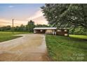 Charming brick home with a metal roof, carport, and a spacious driveway at sunset at 133 Jo Monni Loop, Statesville, NC 28625