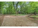 Wide driveway with ample parking leads to a charming home surrounded by mature trees at 1513 Shelby Hwy, Cherryville, NC 28021