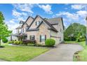 A beautiful home with stone accents, well-manicured lawn and long driveway at 15637 Guthrie Dr, Huntersville, NC 28078