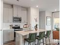 Modern kitchen featuring stainless steel appliances, a breakfast bar, and sleek gray cabinets at 1712 Braemar Village Dr, Monroe, NC 28110