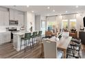 Bright, open-concept living area with hardwood floors, featuring a kitchen, dining area, and living room at 1712 Braemar Village Dr, Monroe, NC 28110