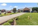 Well-manicured lawn and long driveway leading to a brick home with attached garage at 1759 Nw Pipers Ridge Cir, Conover, NC 28613