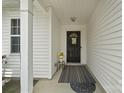 Covered front entry showcases a black door, flowers, and neutral accents at 181 Mott Rd, Mooresville, NC 28115