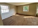 Cozy bedroom with neutral walls, plush carpeting, and bright natural light from two windows at 2020 Longleaf Dr, Charlotte, NC 28210