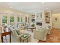 Bright living room with fireplace, built-in shelving, and multiple windows at 2129 Halford Pl, Charlotte, NC 28211