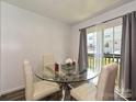Bright dining area features a glass table with four chairs and sliding glass doors at 2715 Sydney Overlook Ln, Charlotte, NC 28269