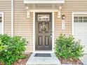 A welcoming front door adorned with a floral wreath, complemented by neatly trimmed bushes and classic exterior details at 2715 Sydney Overlook Ln, Charlotte, NC 28269