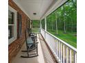 Relaxing porch with rocking chairs, offering a serene view of the surrounding greenery and a classic brick exterior at 300 Hugh Crocker Rd, Matthews, NC 28104