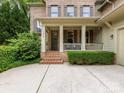 Inviting front porch with brick steps and decorative columns, enhancing the home's charming facade at 3825 Mountain Cove Dr, Charlotte, NC 28216