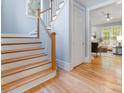 Wooden staircase with white risers and a view into the cozy living room at 3825 Mountain Cove Dr, Charlotte, NC 28216
