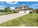 Beautiful two-story home showcasing a long driveway, three-car garage, and lush green lawn at 4321 Tucker Chase Dr, Midland, NC 28107