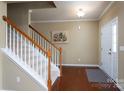 Inviting foyer features hardwood floors, a staircase with white banisters, and a white front door at 4321 Tucker Chase Dr, Midland, NC 28107