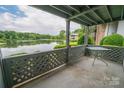 Enjoy a serene waterfront view from this cozy condo balcony with a small outdoor table at 5833 Harris Grove Ln, Charlotte, NC 28212