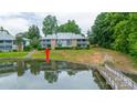 Waterfront condo building with lush greenery, mature trees, and serene pond views, offering a peaceful retreat at 5833 Harris Grove Ln, Charlotte, NC 28212