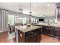 Open kitchen features granite countertops, stainless steel appliances, and dark wood cabinetry at 7318 Agnew Dr, Charlotte, NC 28278