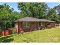 A brick home shows manicured landscaping and decorative shutters, complemented by a modern wooden privacy fence at 851 Gist Rd, Rock Hill, SC 29732