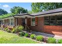 Charming brick home featuring tidy landscaping, decorative shutters, and a welcoming front porch at 851 Gist Rd, Rock Hill, SC 29732