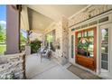 Inviting covered front porch with seating area and decorative wreath on front door at 9075 Blue Ridge Dr, Indian Land, SC 29707