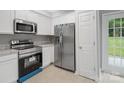 This modern kitchen has new stainless steel appliances, white cabinetry, and ample counter space at 908 Sundance Dr, Gastonia, NC 28054
