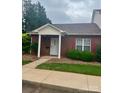 Inviting brick home with a covered front porch supported by white columns, complemented by red shutters and lush landscaping at 102 Brandywine Ne Dr # I-1, Conover, NC 28613