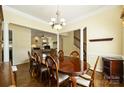 Open-concept dining area with decorative columns, hardwood floors, and views into the living room at 1117 Yarrow St, Matthews, NC 28104