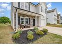 Close up of a charming front porch with stone accents, flower beds, and chair seating at 1121 Freeman View Dr, Albemarle, NC 28001