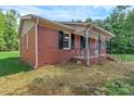 Brick home with black shutters and covered porch, surrounded by green grass at 1154 Stringfellow Rd, Chester, SC 29706