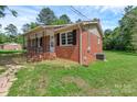 Brick home with covered porch, featuring black shutters and well-kept lawn at 1154 Stringfellow Rd, Chester, SC 29706