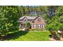Beautiful brick home featuring a well-maintained lawn and professionally landscaped front yard at 129 Willow Tree Ln, Mount Holly, NC 28120