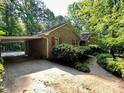 Brick home featuring a covered carport and a walkway surrounded by greenery at 1623 Arbor Way, Albemarle, NC 28001