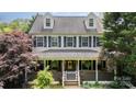 Welcoming two-story home with covered porch, adorned with lush greenery and tasteful decorations at 1687 Windy Hill Ln, Great Falls, SC 29055