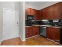 Compact kitchen featuring granite countertops, stainless steel appliances, and dark wood cabinetry at 2125 Southend Dr # 448, Charlotte, NC 28203