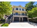 Charming two-story home featuring a brick facade, a black 2-car garage, and an inviting second-story porch at 2925 Westfield Rd, Charlotte, NC 28209