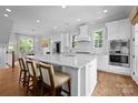Spacious kitchen with white cabinets, marble countertops, and a large island with seating at 2925 Westfield Rd, Charlotte, NC 28209