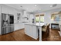 Bright, all-white kitchen featuring a large island, stainless steel appliances, and hardwood floors at 2925 Westfield Rd, Charlotte, NC 28209