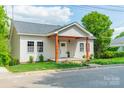 Charming home with light siding, covered front porch, and well-manicured lawn at 322 S Hill St, Gastonia, NC 28052