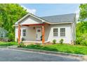 Charming home with light siding, covered front porch, and well-manicured lawn at 322 S Hill St, Gastonia, NC 28052