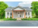 Charming home with a covered porch, complemented by lush greenery and a well-maintained front yard at 322 S Hill St, Gastonia, NC 28052