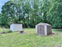 Spacious backyard featuring two storage sheds for all your organizational needs, set in a grassy, tree-lined landscape at 341 Austin Dr, York, SC 29745