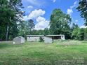 Expansive backyard featuring various outbuildings, surrounded by green space, and backing to a private wooded area at 341 Austin Dr, York, SC 29745
