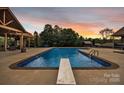 Inviting in-ground pool with diving board, poolside lounge, and covered seating area for relaxation at 3440 17Th Ne Ave, Hickory, NC 28601