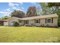 Inviting home featuring a well-maintained lawn, a front porch, and a sliding glass door entrance at 4100 Sudbury Rd, Charlotte, NC 28205