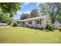 Well-kept single story home with green lawn and a charming walkway leading to the front door at 4100 Sudbury Rd, Charlotte, NC 28205