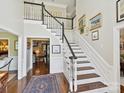 Spacious foyer with hardwood floors, staircase with white railings, and views into other rooms of the home at 4608 Morrowick Rd, Charlotte, NC 28226