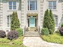 Inviting front entrance with a light blue door, stone walkway, manicured landscaping, and detailed architectural elements at 4608 Morrowick Rd, Charlotte, NC 28226