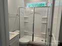 Modern bathroom with a glass-enclosed shower, white cabinetry, and neutral tones at 5103 Heathland Dr # 50, Charlotte, NC 28215